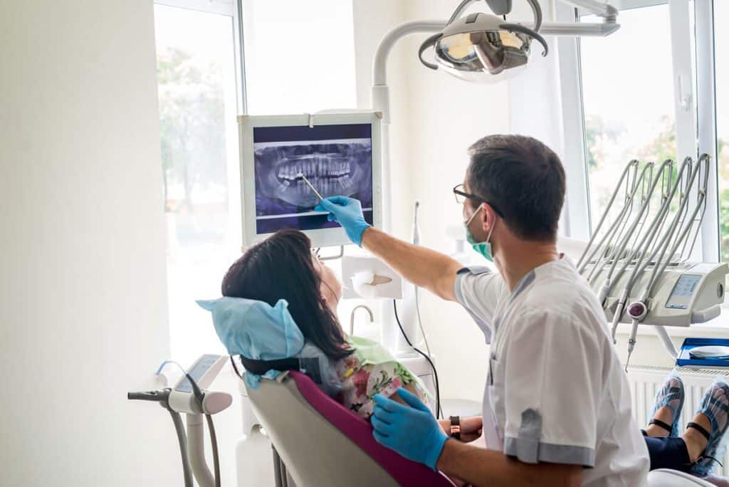 a dentist discusses dental x-rays with a patient